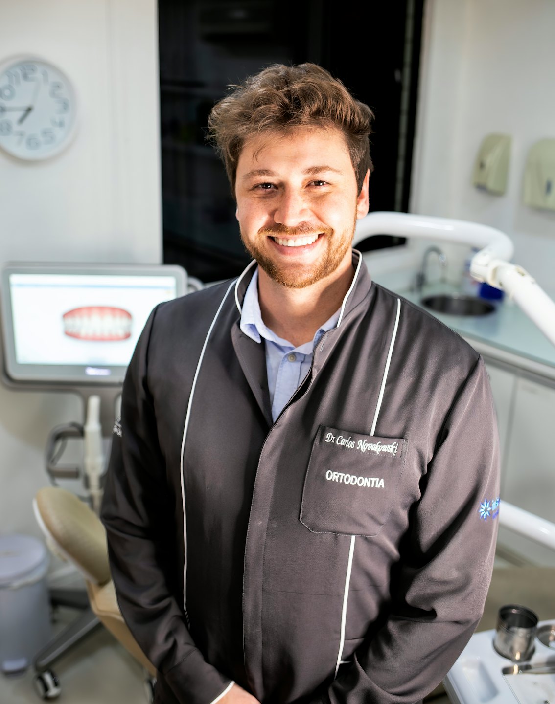 Sorriso di un dentista in una clinica moderna che esamina un modello 3D.