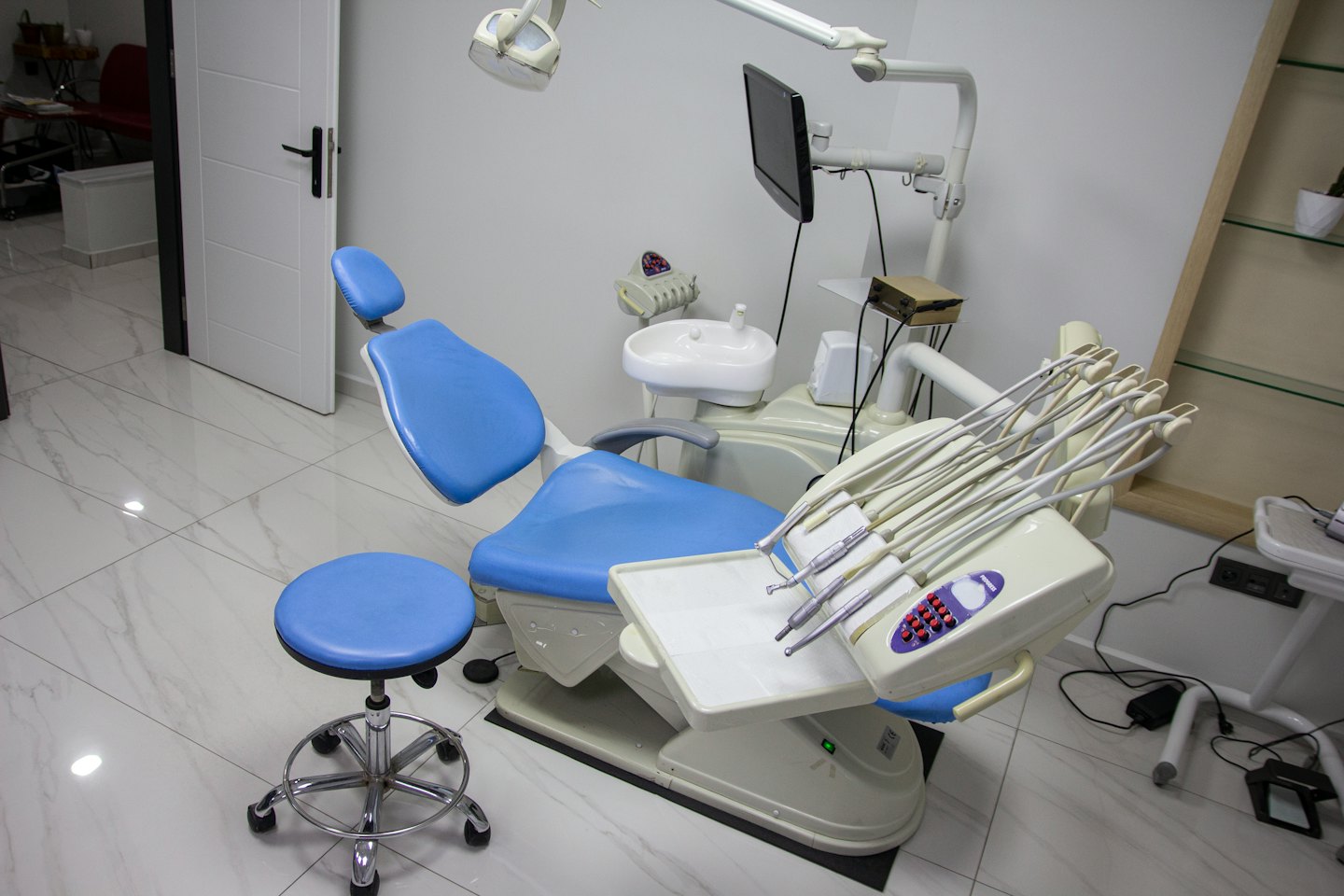 Ambulatorio dentistico vuoto con poltrona blu e attrezzature.