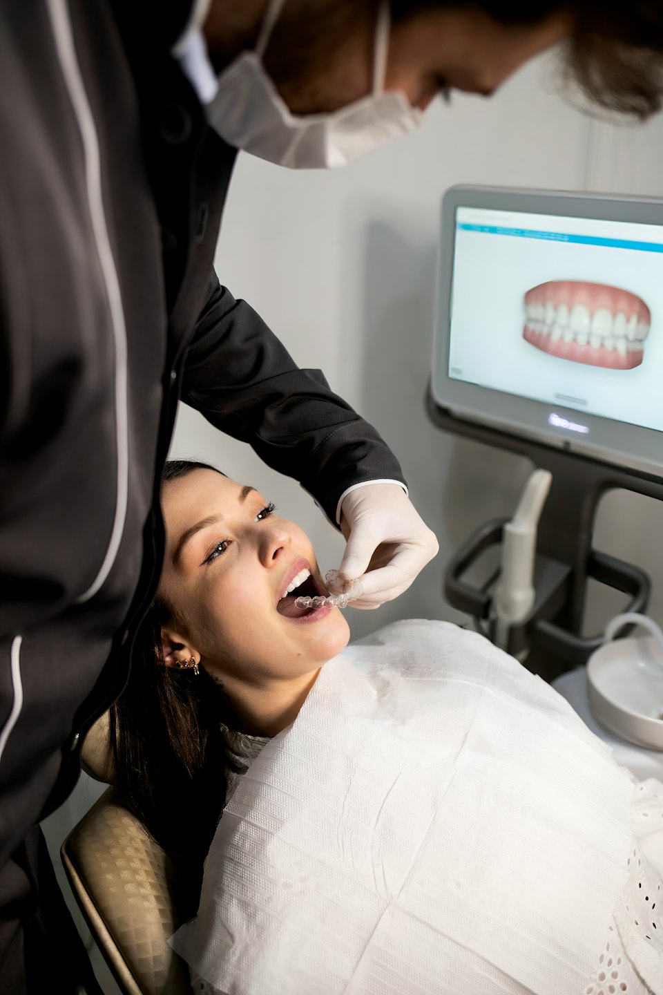 Dentista che applica un allineatore trasparente a un paziente con un modello 3D dei denti.